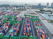 Singapore, Singapore - 06 December 2024: Aerial view of Pasir Panjang Terminal reveals a vibrant tapestry of colorful shipping containers, a testament to global trade against the city's skyline.