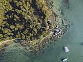 Aerial view of emerald waters meeting the rugged coastline where lush forests stand guard over the Presqu'île de Conleau, Bretagne, France.