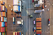 Oakland, United States - 12 May 2020: Aerial view of stacked shipping containers casting long shadows, standing in stark contrast to the bright pavement at 530 Water Street, Oakland.