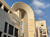 Jerusalem, Israel - 28 October 2019: View of the stark, geometric architecture of the Jerusalem Theater against a bright blue sky, the building's stone facade glowing warmly in the sunlight.