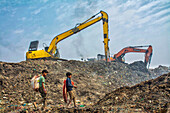 Chattogram, Bangladesch - 12. Februar 2024: Blick auf Kinder, die sich auf einer riesigen Mülldeponie bewegen, wo das kräftige Gelb der Bagger im Kontrast zu den gedämpften Farbtönen des Abfalls steht.