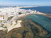 Aerial view of the Castillo de San Sebastián guarding the shoreline where the turquoise waters meet the sandy beach, Cádiz, Andalusia, Spain.