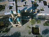 Luftaufnahme der türkisfarbenen Kuppeln der Chor-Minor-Madrassa im Kontrast zu den sandfarbenen Farbtönen des umliegenden Hofes und der Gebäude, Buxoro, Buxoro Viloyati, Usbekistan.