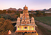 Aerial view of the Maha Kalyug Mandir Medine Bambous temple stands majestically against a backdrop of distant mountains, Mauritius_Maha Kalyug Mandir Medine Bambous, Rivière Noire District, Mauritius.