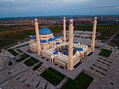 Aerial view of the Hazrat Sultan Mosque stands majestically with its cream-colored walls, blue domes, and towering minarets, Astana, Astana, Kazakhstan.