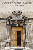 View of weathered stone facade and inviting wooden doors of a Catholic church, whispering tales of history and faith in Scanno, Abruzzo, Italy.