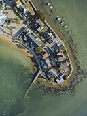 Luftaufnahme der Halbinsel Conleau, wo Gebäude auf das Meer treffen, eine ruhige Szene mit kontrastreichen Grün- und Brauntönen, Presqu'île de Conleau, Bretagne, Frankreich.
