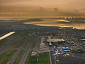 Aerial view of the ongoing construction work of Navi Mumbai International Airport(NMIA), runway, and the terminal building bathed in the warm glow of the sunset, Navi Mumbai, Maharashtra, India.