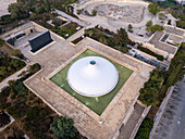 Aerial view of the Shrine of the Book's stark white dome contrasting with the dark memorial hall, amidst Jerusalem's landscape, Jerusalem, Israel.
