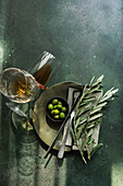 Place setting with olive branches, green olives, amber wine