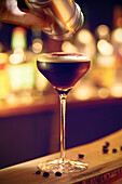 Espresso martini topped with cocoa powder in a bar atmosphere