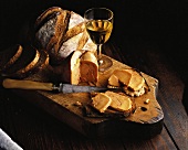 Brot mit Gänsestopfleber und Wein auf einem Holzbrett