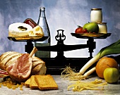 Stillleben mit verschiedenen Lebensmittelgruppen (Milchprodukte, Obst, Gemüse, Teigwaren etc.)
