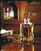 Whisky-Karaffe und Glas mit Zeitung und Brille im gemütlichen holzvertäfelten Raum