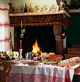 Set table with cured ham on bed of hay and fireplace