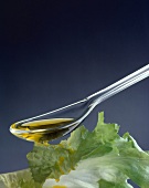 Olivenöl über Blattsalat träufeln