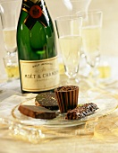 Schokoladenkonfekt auf einem Glasteller mit Champagner