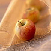 Zwei Äpfel auf zarter Tischdecke