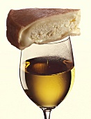 Ein Glas Munsterkäse auf einem Glas Weißwein