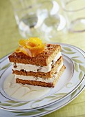 Layered chilled gingerbread and cream dessert with orange sauce