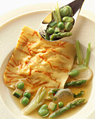 Crab ravioli with green vegetables and stock