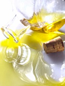 Glasflasche Olivenöl spiegelt sich im Öl das herausfliesst