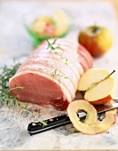 Zum Braten vorbereitetes Schweinefilet mit Apfel, Salz und Thymian