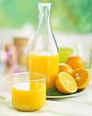 Orangensaft in Glas und Flasche
