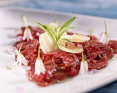 Veal carpaccio with onion flowers and lavender salt