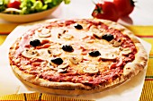 Pizza mit Ziegenkäse und schwarzen Oliven