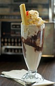 A large ice cream sundae with vanilla, chocolate ice cream and whipped cream