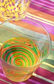 A glass with a colourful spiral pattern