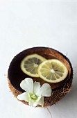Zitronenwasser für die Hände in einer Kokosschale