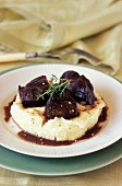Beef cheeks braised in red wine on mashed potatoes with olive oil