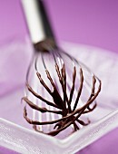Whisk with melted chocolate
