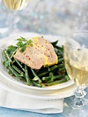 Sliced foie gras on a bed of green beans