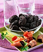 Dried plums and rolls of ham