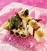 Chicken,cheese and dried tomato brochettes on morel cannellonis