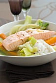 Steam-cooked piece of salmon with vegetables