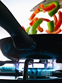 Cooking peppers in a frying pan on a gas cooker
