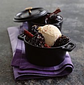 Ice cream with baked plums and spices in a cocotte pot