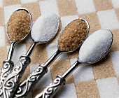 Brown and white sugar on spoons