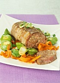Thick round stuffed pork fillet with vegetables