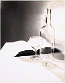 Empty bottle and glass and open book