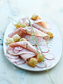Thinly sliced parslied boiled ham,radish Carpaccio and small fritters