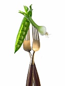 "Two forks with pea pod and spring onion ;light lunch"