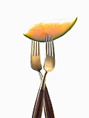 Two forks with slice of melon