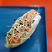 A chicory boat with salmon tatar and lentil sprouts