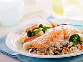Thick piece of salmon in cream sauce with rice and vegetables