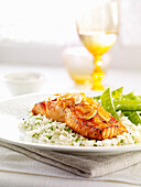 Grilled piece of salmon with almonds on a bed of rice